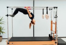 필라테스와 스트레칭의 차이점과 장점 a woman doing a handstand on a pivot machine