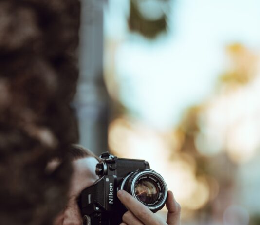 저속 노화 팁 person using black Nikon DSLR camera