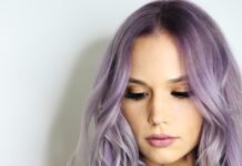 건강한 모발을 위한 올바른 헤어 케어 습관 purple haired woman in black top leaning on wall