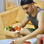 댄스 전후 영양학: 지치지 않는 에너지를 위한 ‘스마트 식사법’ a man sitting at a table with a plate of food