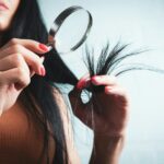건강한 머릿결, 생활 습관이 먼저다… 실천 가능한 헤어 케어 트렌드 Woman examining split ends of hair with magnifying glass