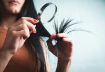 건강한 머릿결, 생활 습관이 먼저다… 실천 가능한 헤어 케어 트렌드 Woman examining split ends of hair with magnifying glass