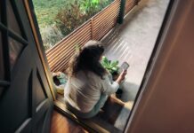 만성피로, 일상에서 벗어나는 실천법은? Woman sitting on balcony with smartphone