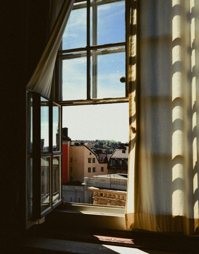 Photo by Karl Hedin a view of a city through a window