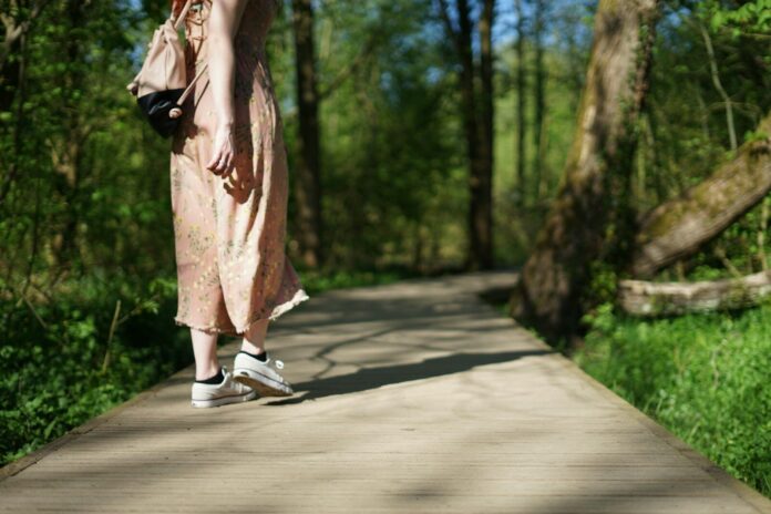 Photo by Old Youth woman walking on forest trail