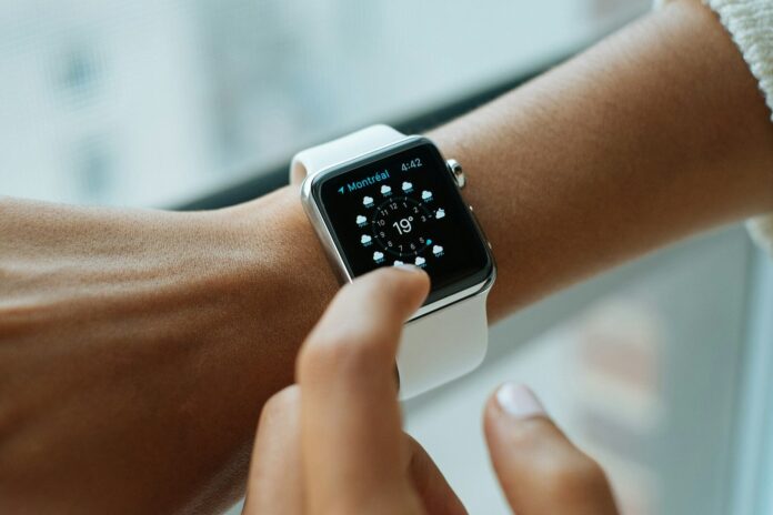 Photo by Luke Chesser person wearing silver aluminium case Apple Watch with white Sports Band